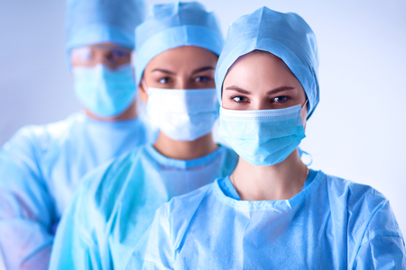 Surgeons team, man and woman wearing protective uniforms,caps and masks.の写真素材