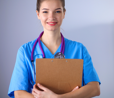 Smiling female doctor with a folder in uniform standingの写真素材
