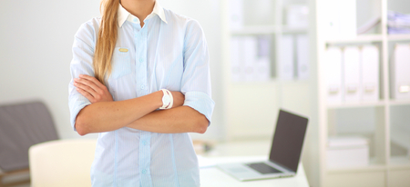 Attractive businesswoman standing near desk in the officeの写真素材