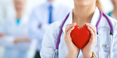 Female doctor with stethoscope holding heart .の写真素材