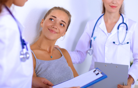 Smiling female doctor with a folder in uniform standingの写真素材
