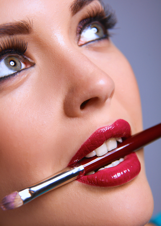 Womans lips holding make up brush.の写真素材