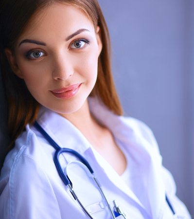 Young doctor woman with stethoscope isolated on grey backgroundの写真素材