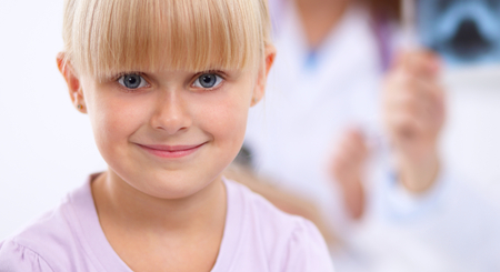 Female doctor examining child with stethoscope at surgery,isolatedの写真素材
