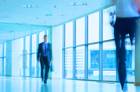 Businesspeople walking in the corridor of an business center.の写真素材