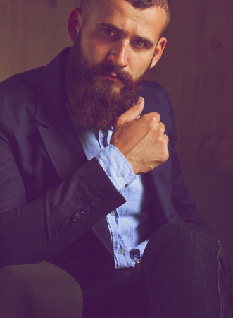 Businessman sitting on sofa in office lobbyの写真素材