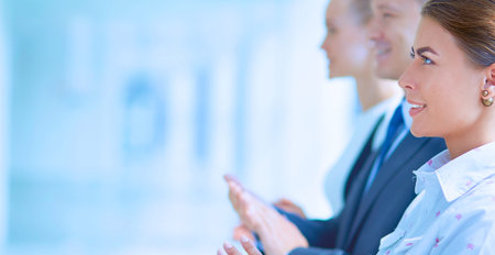 Smiling business people applauding a good presentation in the office .