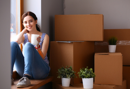 Woman in a new home with cardboard boxes.の写真素材
