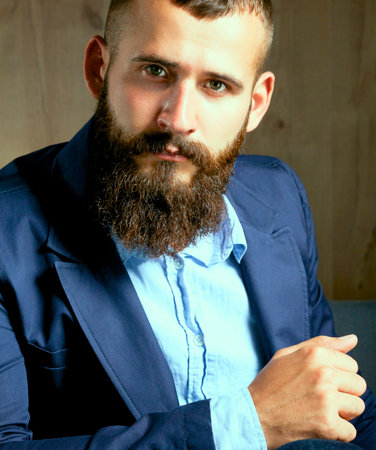 Businessman sitting on sofa in office lobbyの写真素材