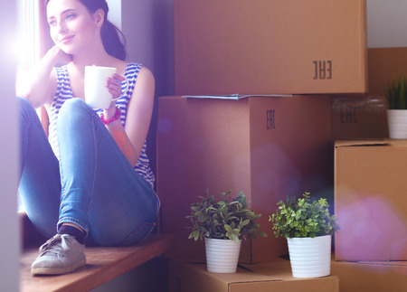 Girl sitting on windowsill at new home.の写真素材