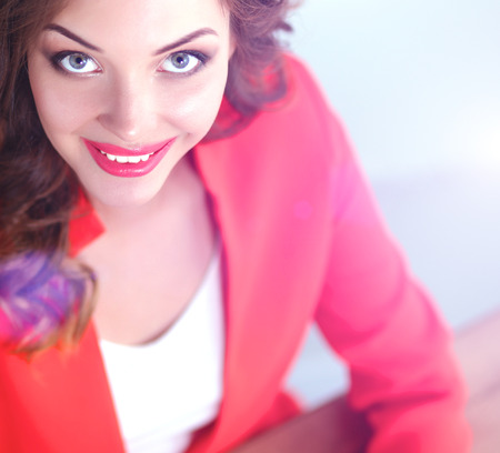 Attractive woman sitting at desk in office, working with laptopの写真素材