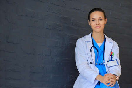 Young woman doctor sitting near wallの写真素材