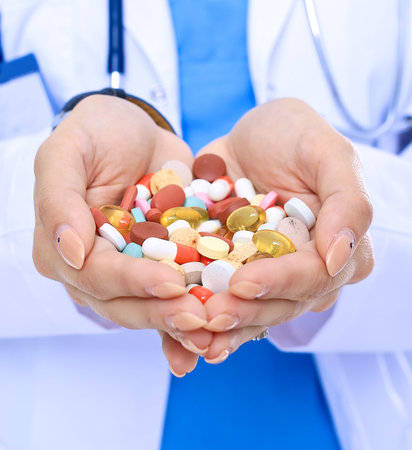 Doctor holding heap of drugs in a handの写真素材