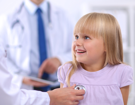 Female doctor examining child with stethoscope at surgery,isolatedの写真素材