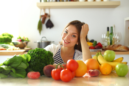 Young woman sitting near desk in the kitchenの写真素材