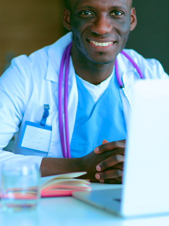Young african doctor working on laptop at deskの写真素材