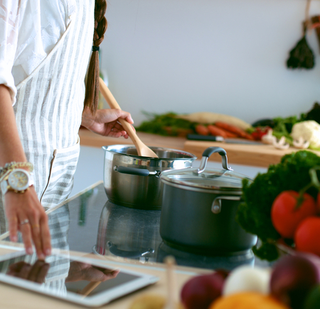 Cooking woman in kitchen with wooden spoonの写真素材
