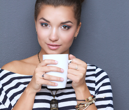 Portrait of young woman with cup tea or coffee.の写真素材