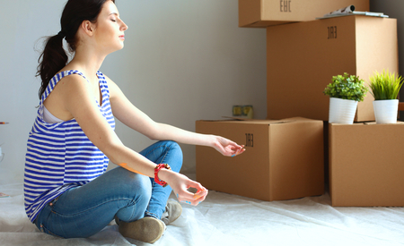 Woman in a new home with cardboard boxes.の写真素材