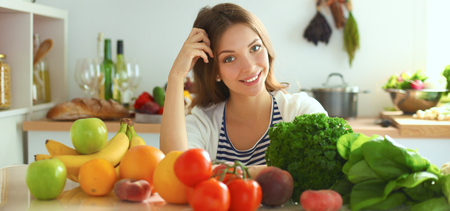 Young woman sitting near desk in the kitchen .の写真素材
