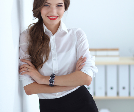 Attractive businesswoman standing near wall in office .の写真素材