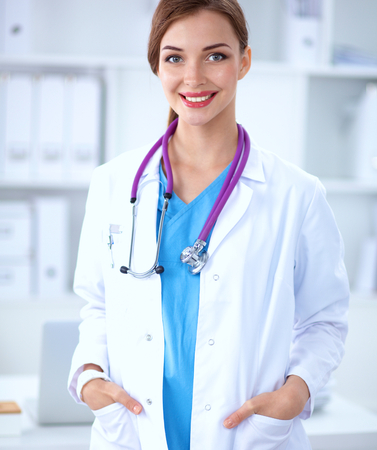Portrait of young woman doctor with white coat standing in hospital .の写真素材