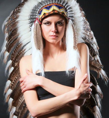 Beautiful woman in native american costume with feathersの写真素材
