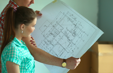 Portrait of young couple moving in new home with plane.の写真素材