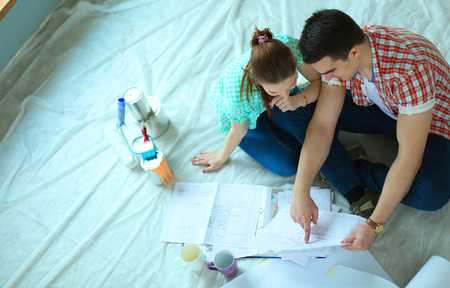 Young couple sitting on floor and calculating about they savings.の写真素材