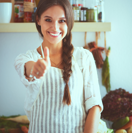 Young woman standing near desk in the kitchen .の写真素材