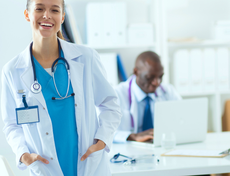 A smiling female doctor with a folder in uniform indoorsの写真素材