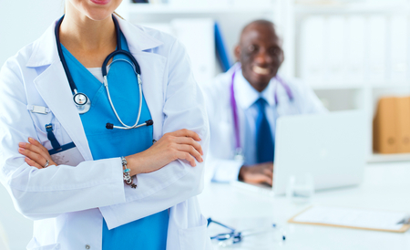 A smiling female doctor with a folder in uniform indoorsの写真素材