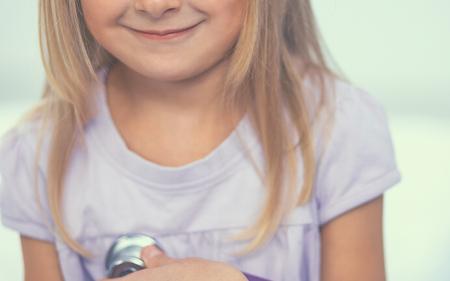 Female doctor examining child with stethoscope at surgery,isolatedの写真素材