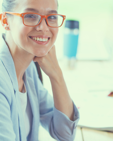 Business woman sitting in her office using a tablet computerの写真素材