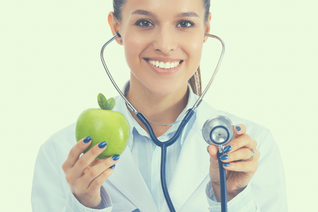 Medical doctor woman examining apple with stethoscopeの写真素材
