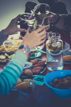 People with drinks while sitting at the dining tableの写真素材