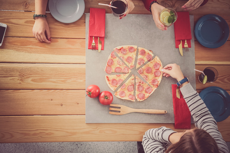 Group of people eating pizzaの写真素材