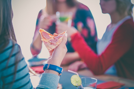Beautiful young woman eating a slice of pizzaの写真素材
