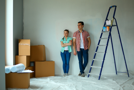 Guy and girl standing near white wall next to ladderの写真素材