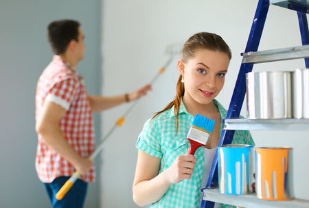 Young couple painting wall at homeの写真素材