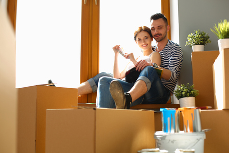 Young happy couple sitting in the new homeの写真素材