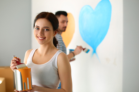 Young couple painting wall at homeの写真素材