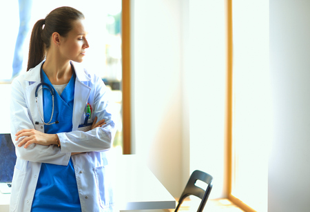 Woman doctor with stethoscope standing with arms crossedの写真素材