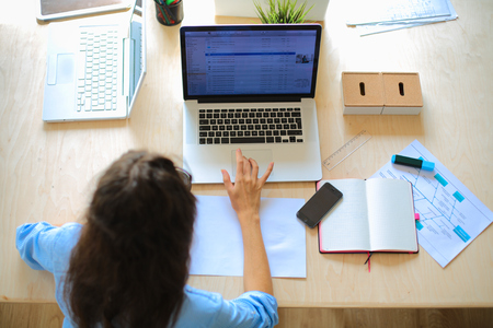 Young woman sitting at office table laptopの写真素材