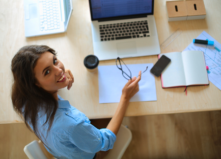 Young woman sitting at office table laptopの写真素材