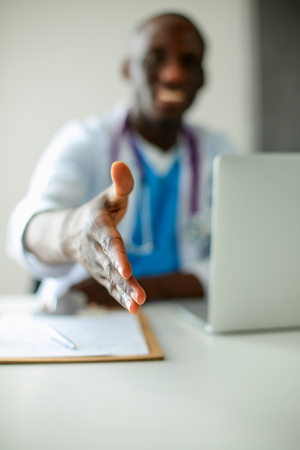 Male doctor handshake at his patient in medical officeの写真素材