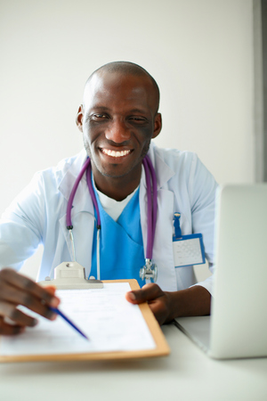 Male doctor sitting at his deskの写真素材