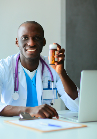 Close-up of male doctor giving jar of pills to patient.の写真素材