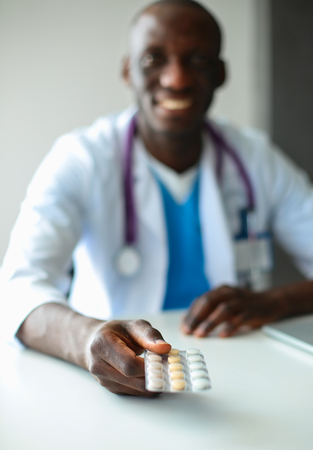 Close-up of male doctor giving jar of pills to patient.の写真素材