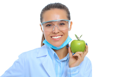 Smiling woman doctor with a green apple.の写真素材